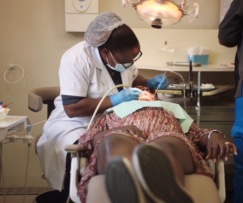 A dental professional performs a procedure on a patient in a clinic
